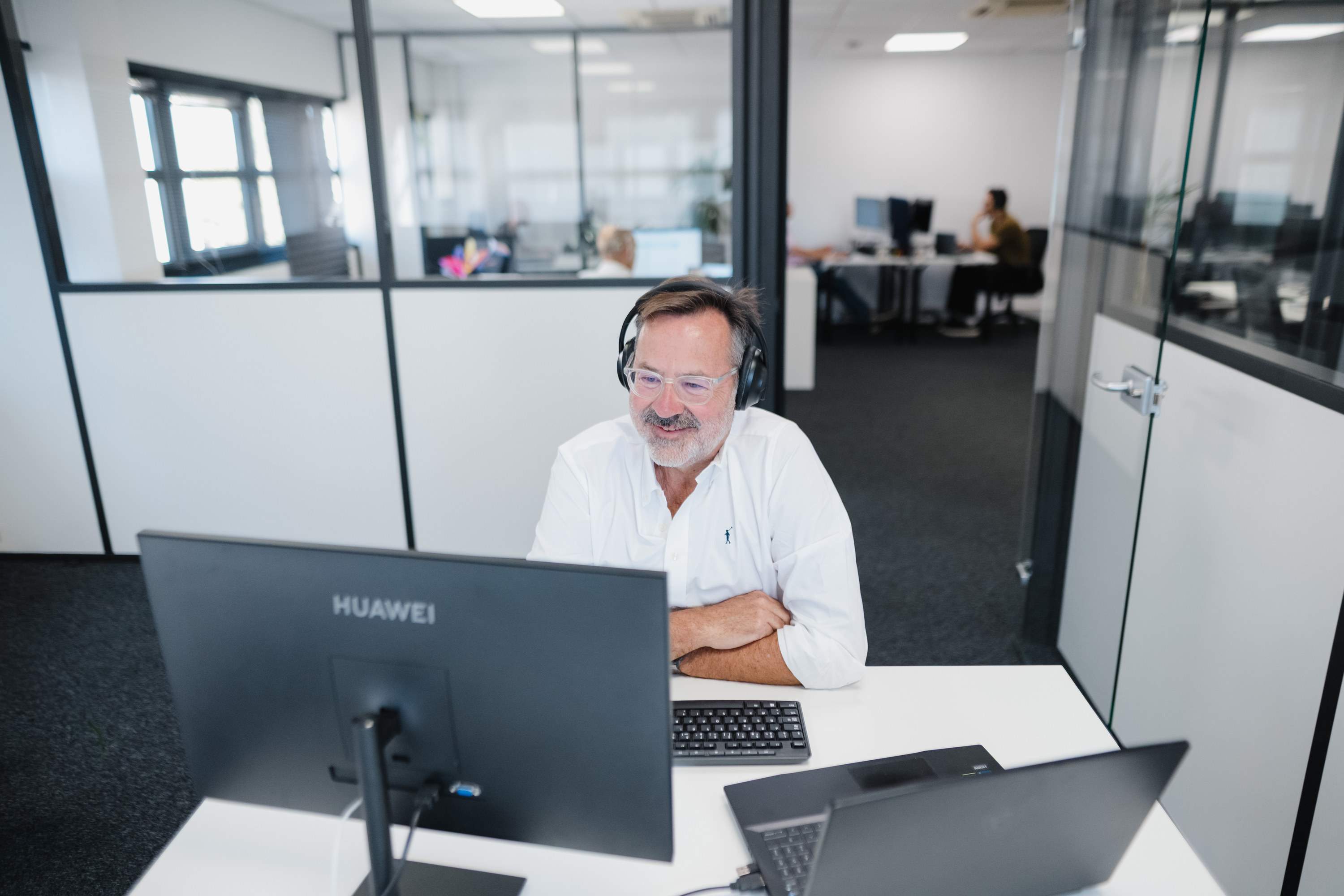 Jean-Luc Javelaud à son bureau, casque sur les oreilles, dans l’open space de Socic